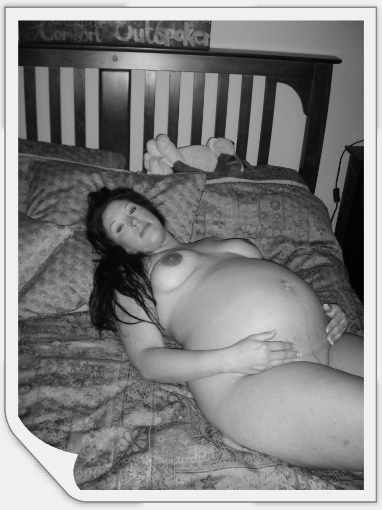 A naked pregnant woman sits