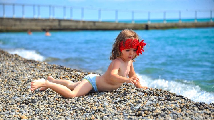 Children at sea sunbathe girls