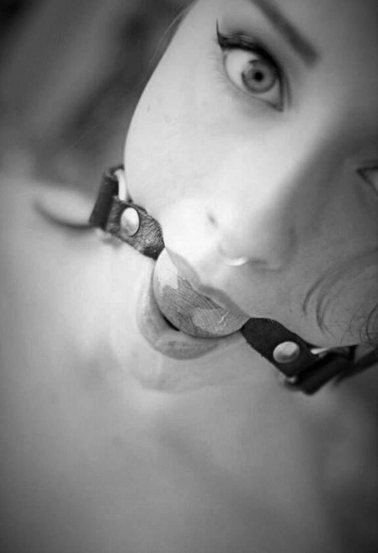 Girl with a gag in the mouth of saliva