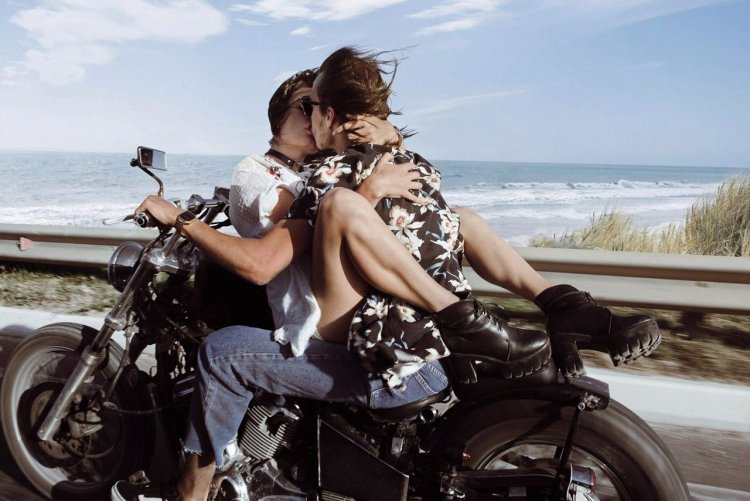 A guy with a girl on a motorcycle
