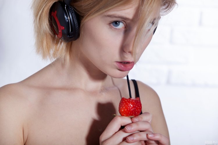 A woman with red lips eats strawberries