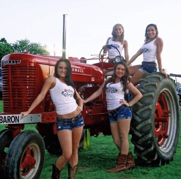 Girls on the background of tractors